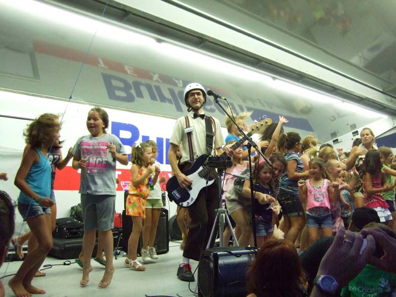 Photo of band playing music and kids dancing along